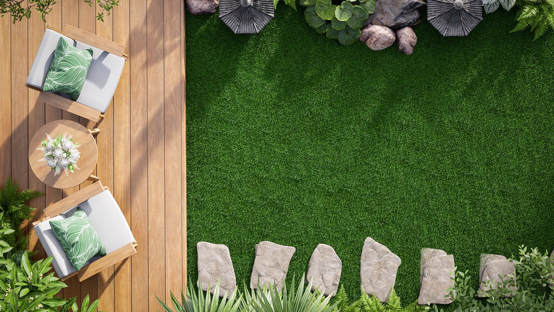 Wooden deck with two chairs, small round table with flowers, surrounded by green grass, potted plants, and stone pathway for a serene setting.