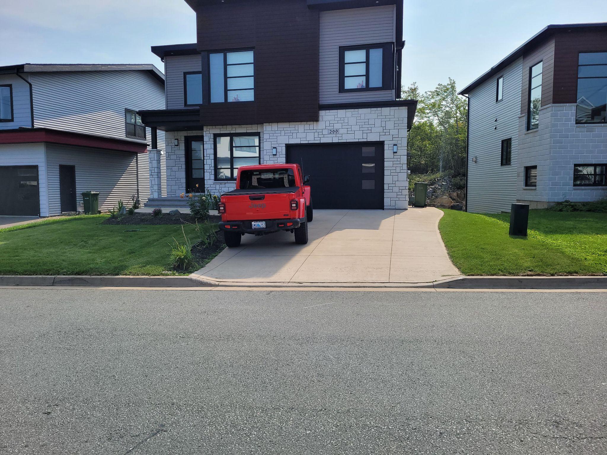 Modern house with red truck parked in driveway.